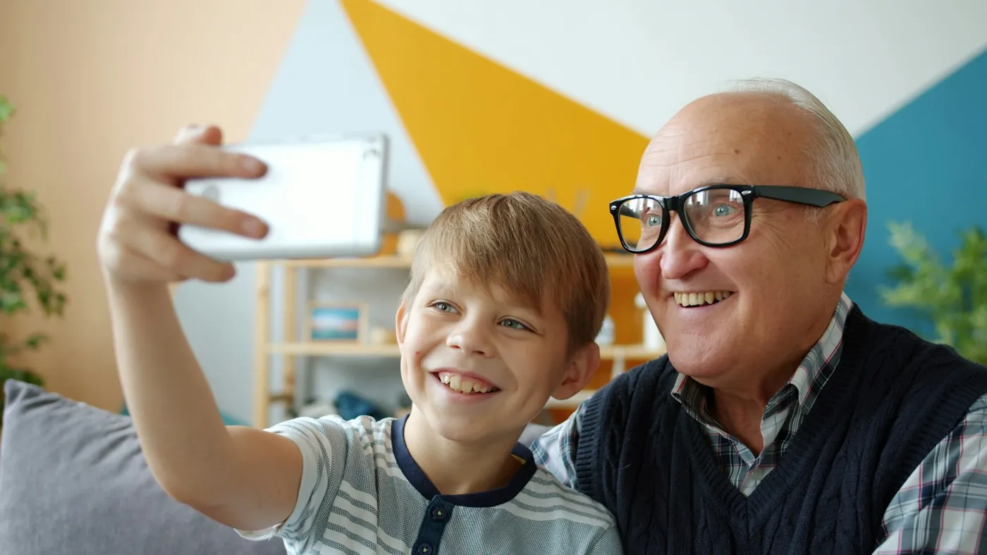 Abuelo y nieto haciéndose un selfie en casa